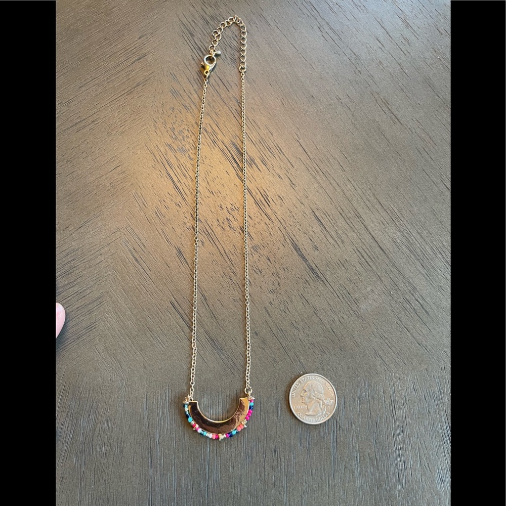 Gold beaded crescent necklace.